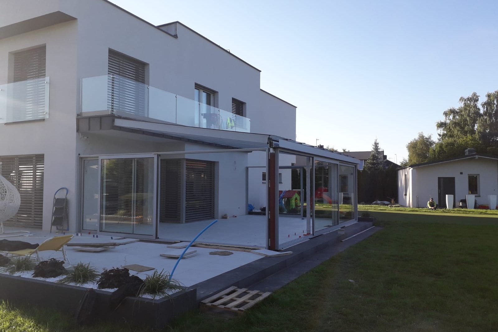 Moderne witte villa met doorlopend glazen balkon en grote raampartijen
