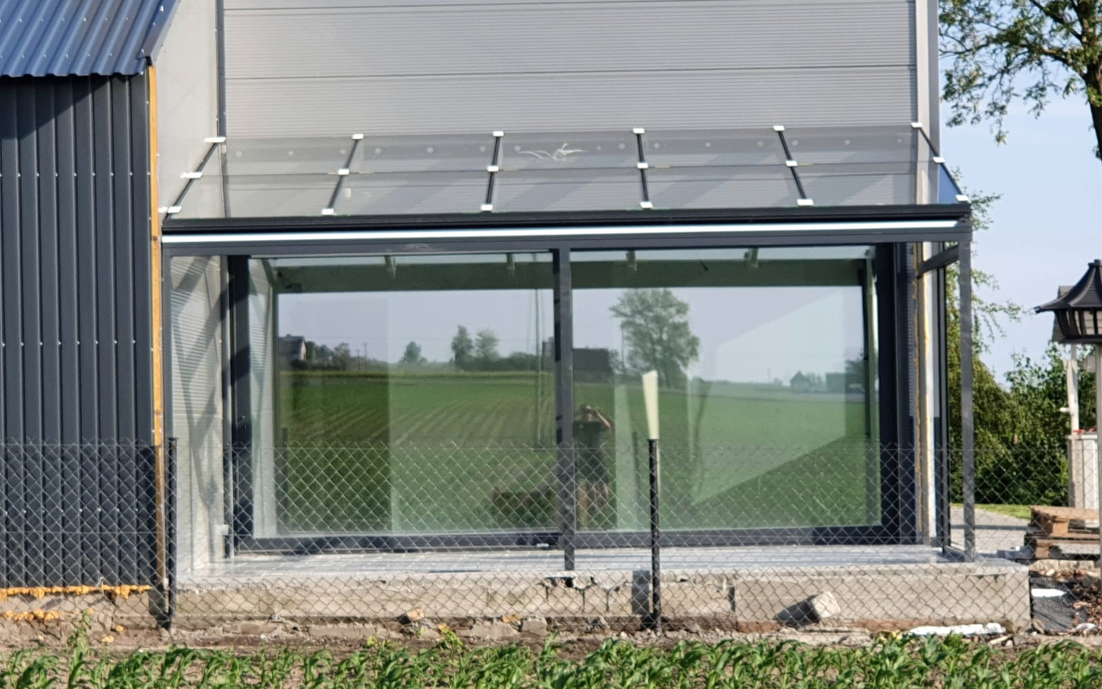 Glazen schuifsysteem in een aluminium tuinkamer met uitzicht over open landerijen