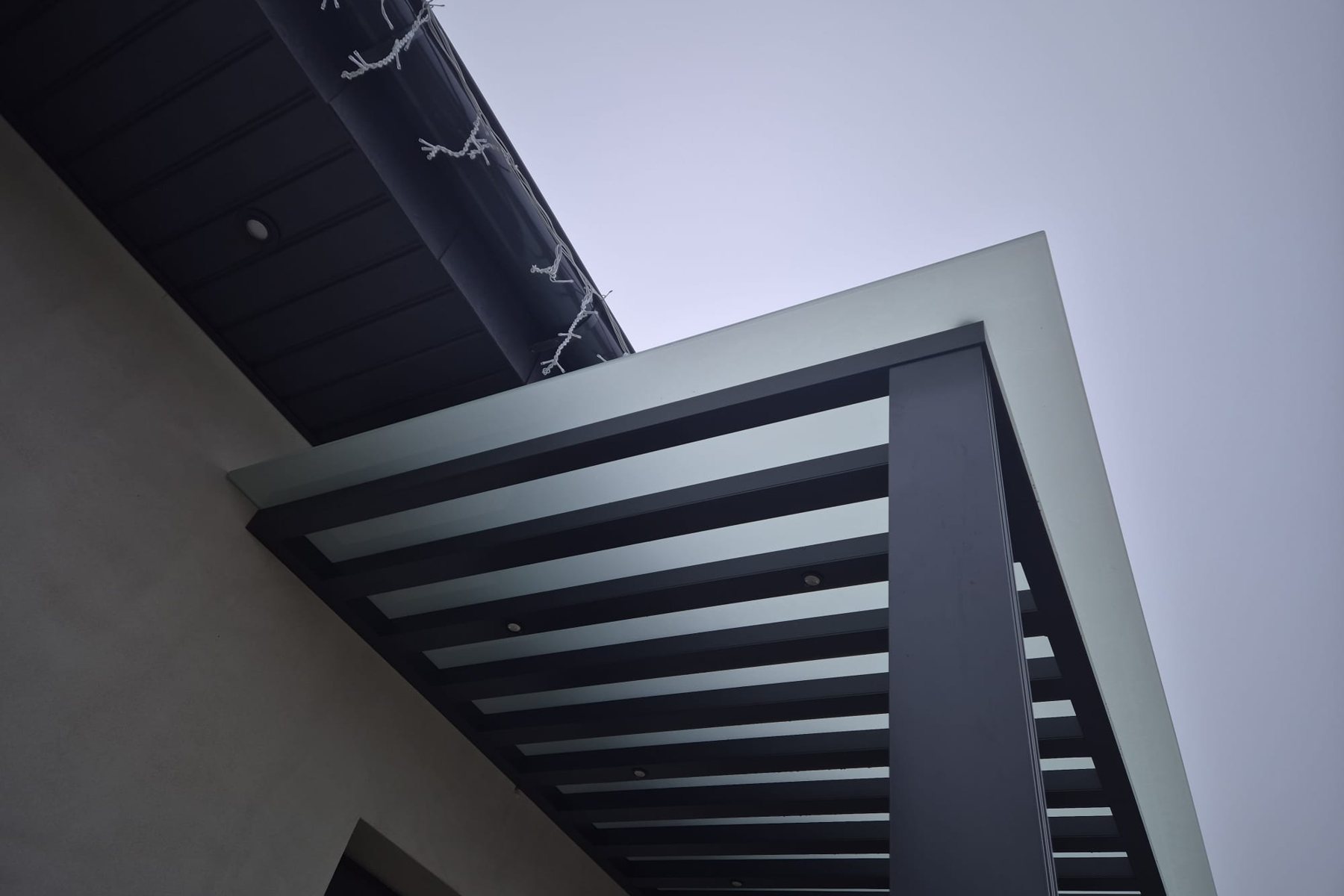Detail van de aluminium lamellen van de luifel.