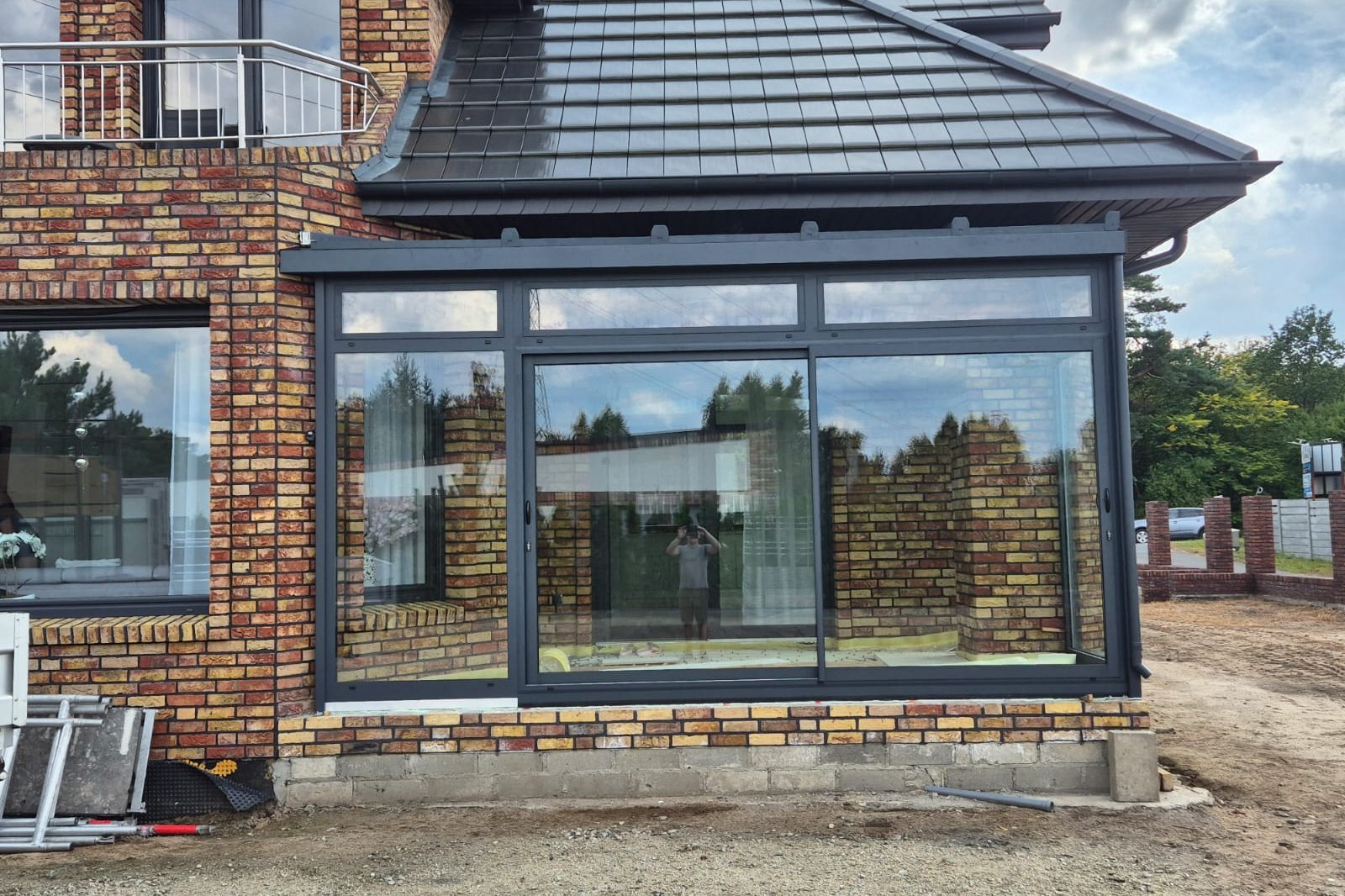 Antraciet aluminium kozijnen en schuifpui met isolerende beglazing in bakstenen metselwerk