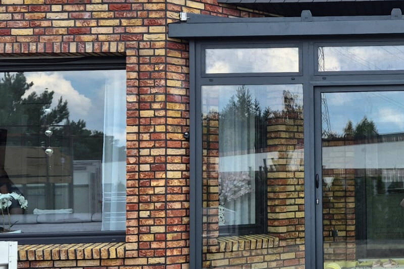 Detail van het aluminium kozijn met isolerende beglazing in het metselwerk van de woning.